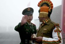 A Chinese and an Indian soldier at their countries' border along the Himalayas.