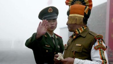 A Chinese and an Indian soldier at their countries' border along the Himalayas.