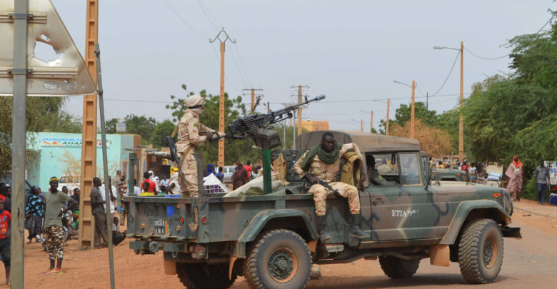 Malian soldiers ride on a pick up truck with a machine gun on November 13, 2018, in Gao