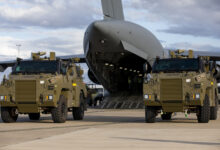 Two Bushmaster protected mobility vehicles bound for Ukraine wait to be loaded onto a C-17A Globemaster III aircraft at RAAF Base Amberley, Queensland. *** Local Caption *** The Australian Government has provided further support to the Government of Ukraine by gifting 20 Bushmaster Protected Mobility Vehicles, including two ambulance variants, to aid the Government of Ukraines response to Russias unrelenting and illegal aggression. Australias response follows a direct request from President Zelenskyy during his address to a joint sitting of the Parliament of Australia on 31 March 2022. The Bushmaster Protected Mobility Vehicle was built in Australia to provide protected mobility transport, safely moving soldiers to a battle area prior to dismounting for close combat. The Bushmaster Protected Mobility Vehicle is well suited to provide protection to the Ukrainian Armed Forces soldiers and Ukrainian civilians against mines and improvised explosive devices, shrapnel from artillery and small arms fire. The vehicles have been painted olive green to suit the operating environment. Additionally, a Ukrainian flag is painted on either side with the words United with Ukraine stencilled in English and Ukrainian to acknowledge our commitment and support to the Government and people of Ukraine. The ambulances will have the traditional red cross emblem. The Bushmaster Protected Mobility Vehicles will be fitted with radios, a global positioning system and additional bolt-on armour increasing their protection.