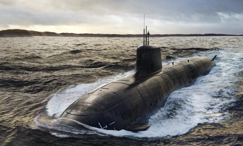 An Australian submarine surfaces from the waters in the foreground. Land is seen peeking in the far background, with the whole scene illuminated by sunlight peering out of the clouds above.