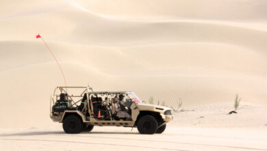 Side view of GM Defense’s Infantry Squad Vehicle driving on sand at UAE Armed Forces Summer Trials