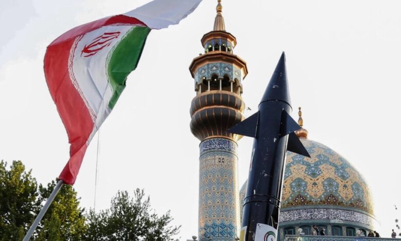 Iranians lift up a flag and the mock-up of a missile during a celebration following Iran's missiles and drones attack on Israel, on April 15 2024, at Palestine square in central Tehran