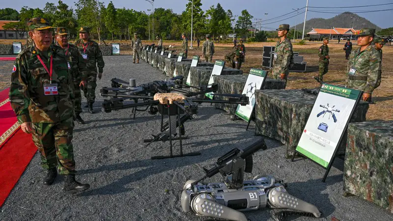 Cambodian Armed Forces commanders inspect drones and a machine gun equipped robot battle "dog" displayed in front of Chinese soldiers during the Cambodian-Chinese Dragon Gold 2024 drill