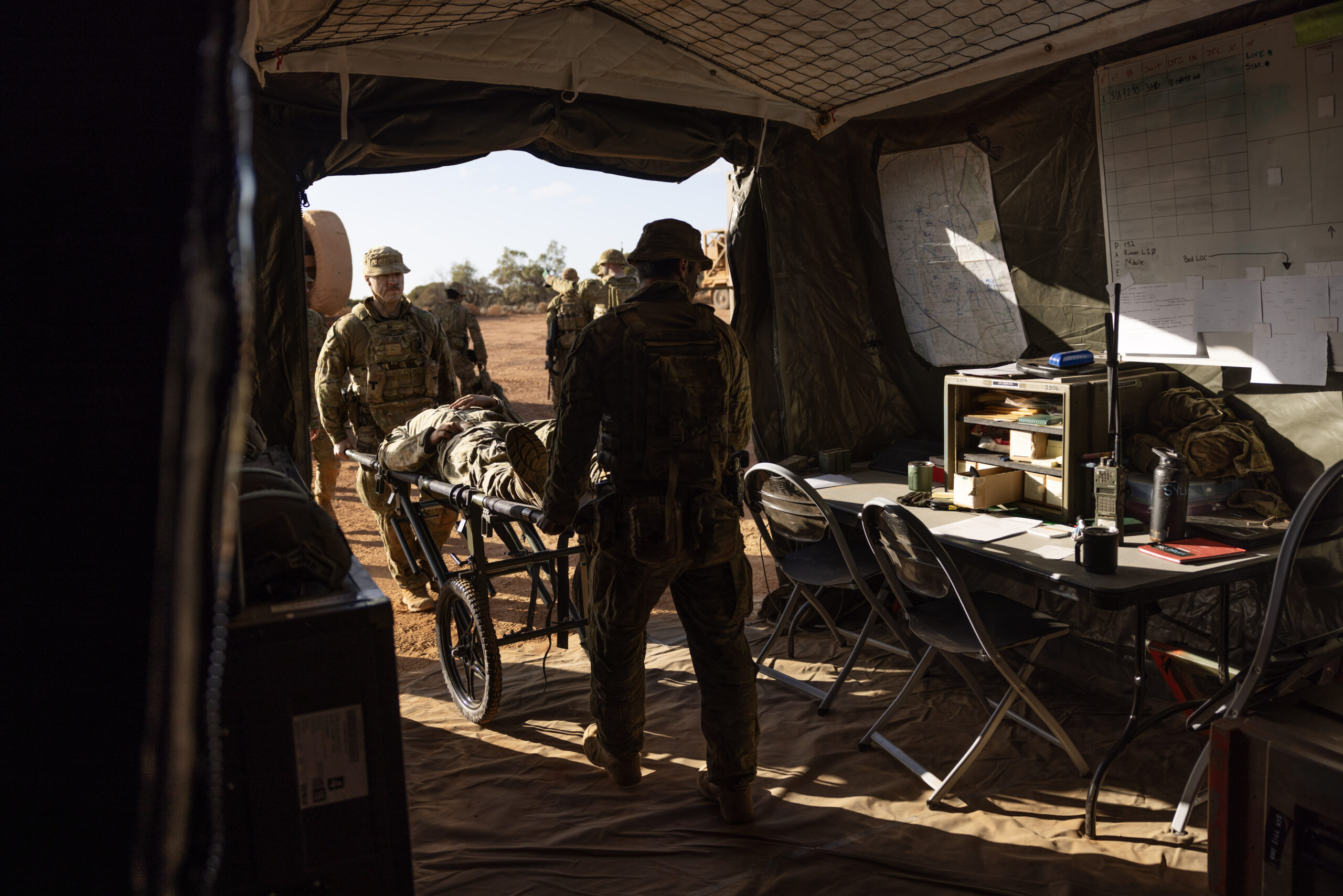 Australian Army medic Private Kerrod Simmons (left) from the 3rd Health Battalion helps deliver a simulated casualty to the Role 2 Basic field hospital during Exercise Rhino Run at Cultana Training Area. *** Local Caption *** The 3rd Health Battalion deployed their Role 2 Basic into the field environment on Exercise Rhino Run 2024. The Role 2 Basic is a manoeuvrable and deployable field hospital designed to offer urgent medical care, including resuscitation, surgery and critical care post-evacuation via medics in the field. The Role 2 Basic is suitable for all shape, deter and respond operations and is able to be deployed at short notice due to its ease of movement.Exercise Rhino Run 2024 is the culminating force generation event for the 9th Brigade in 2024 involving 1st Armoured Regiment, 7th Battalion, the Royal Australian Regiment, 10th/27th Battalion, Royal South Australia Regiment, 9th Combat Service Support Battalion, Headquarters 9th Brigade personnel, and equipment external supports from 3rd Health Battalion and United States Marine Corps. The activity includes a number of carefully synchronised unit live and dry fire activities in the Cultana Training Area (CUTA) with Direct Command Units working together to deliver individual and team training outcomes through supported and supporting arrangements.