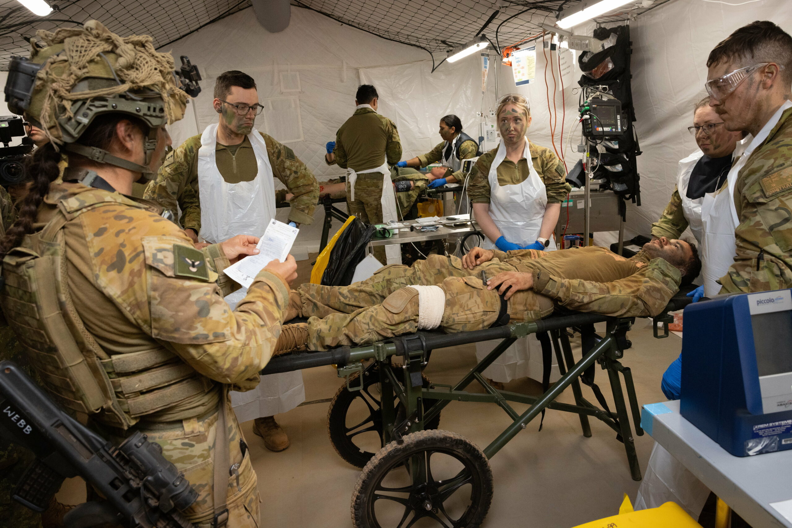 Australian Army medical specialists receive a simulated casualty in the Role 2 Basic resuscitation bay during Exercise Rhino Run at Cultana Training Area. *** Local Caption *** The 3rd Health Battalion deployed their Role 2 Basic into the field environment on Exercise Rhino Run 2024. The Role 2 Basic is a manoeuvrable and deployable field hospital designed to offer urgent medical care, including resuscitation, surgery and critical care post-evacuation via medics in the field. The Role 2 Basic is suitable for all shape, deter and respond operations and is able to be deployed at short notice due to its ease of movement.Exercise Rhino Run 2024 is the culminating force generation event for the 9th Brigade in 2024 involving 1st Armoured Regiment, 7th Battalion, the Royal Australian Regiment, 10th/27th Battalion, Royal South Australia Regiment, 9th Combat Service Support Battalion, Headquarters 9th Brigade personnel, and equipment external supports from 3rd Health Battalion and United States Marine Corps. The activity includes a number of carefully synchronised unit live and dry fire activities in the Cultana Training Area (CUTA) with Direct Command Units working together to deliver individual and team training outcomes through supported and supporting arrangements.