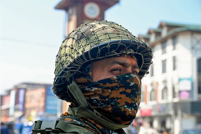 An Indian paramilitary trooper stands guard along a street in Srinagar.