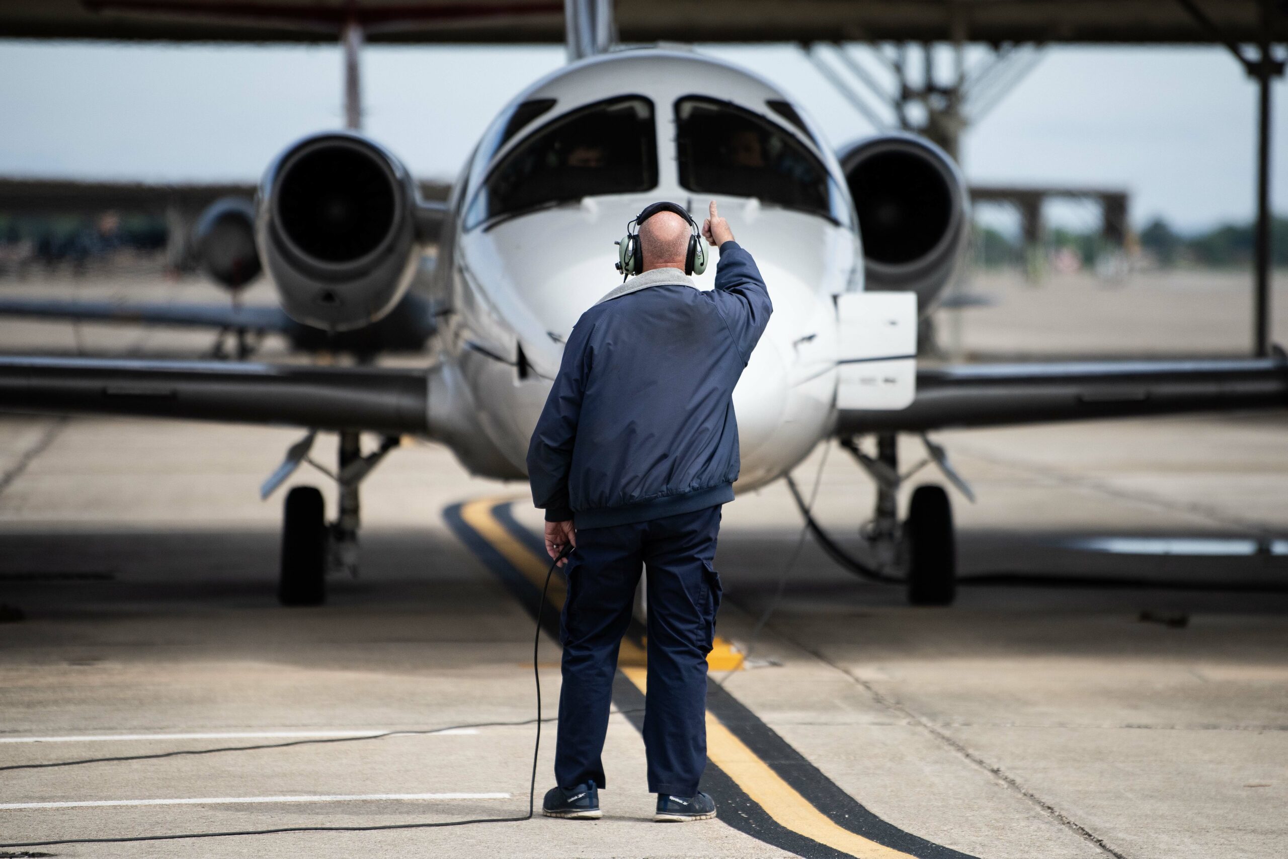 A 12th Maintenance Group aircraft maintenance technician signals to the pilots of the T-1 Jayhawk during the last 99th Flying Training Squadron’s Pilot Instructor Training flight May 17, 2024, at Joint Base San Antonio-Randolph, Texas. The Air Force is divesting the T-1 as a part of its ongoing realignment of Undergraduate Pilot Training. As the aircraft is divested, the units will transition to Air Mobility Fundamentals-Simulator training which will provide an efficient, medium-cost training program to learn required fundamentals and bridge the gap between training aircraft. (U.S. Air Force photo by Sean Worrell)