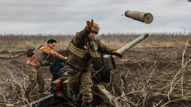 A Ukrainian serviceman of an artillery unit throws an empty shell as they fire towards Russian positions on the outskirts of Bakhmut, eastern Ukraine