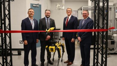 From left: Darrell Phillipson, director, Air Force Research Laboratory, or AFRL, Materials and Manufacturing Directorate; Dr. Sean Donegan, Digital Manufacturing Research Team lead; Timothy Sakulich, AFRL executive director; and Dr. Charles Ormsby, Manufacturing, Industrial Technologies and Energy division chief observe as Boston Dynamics robot Astro cuts a ceremonial ribbon, officially opening the new Collaborative Automation for Manufacturing Systems Laboratory at Wright-Patterson Air Force Base, July 23, 2024. (U.S. Air Force photo / Sarah Perez)