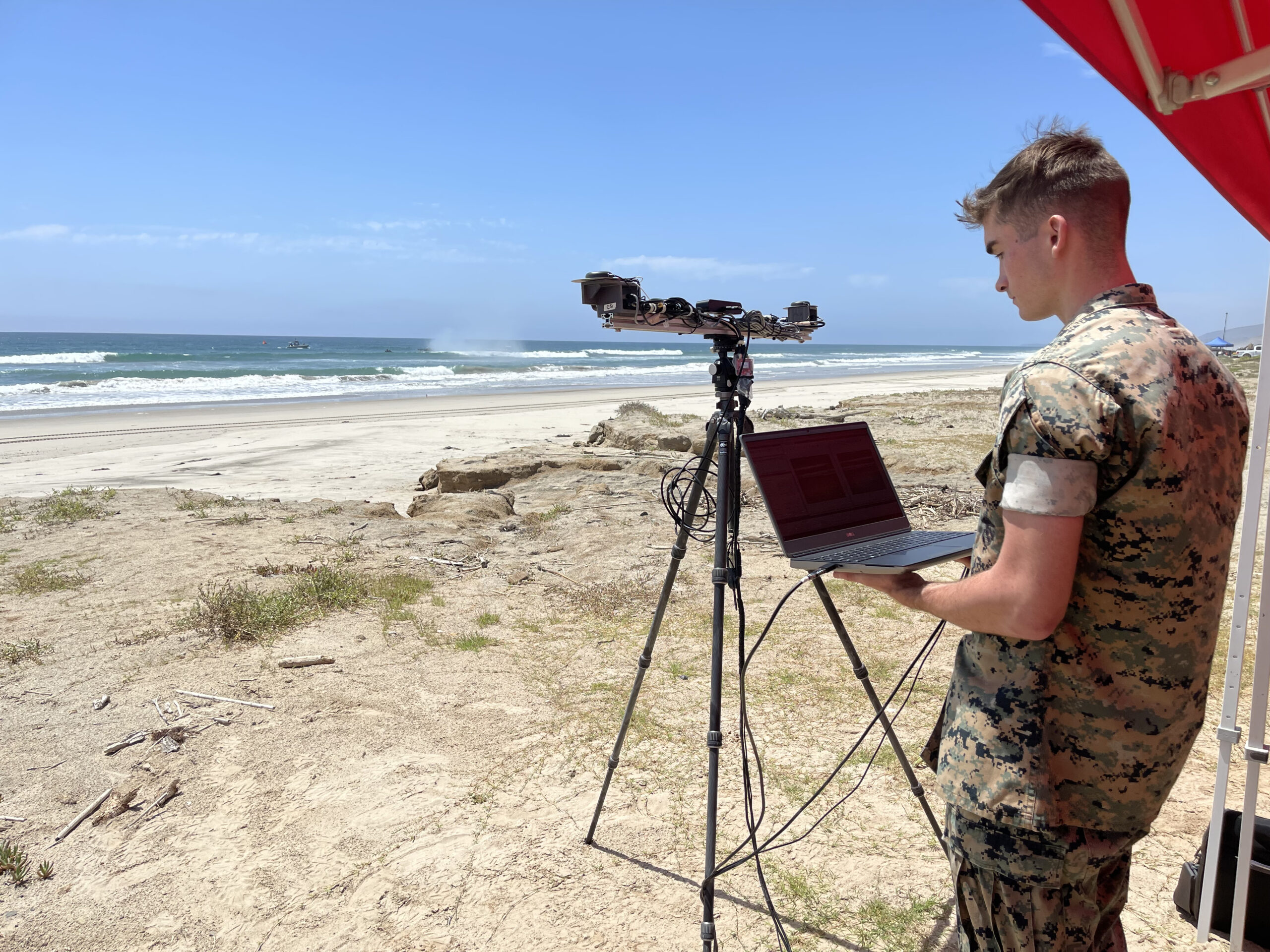 U.S. Marine Corps Cpl. Gideon Morrill, a weather forecaster from 1st Intelligence Battalion is introduced to LittoralLens, a computer-vision system enabling automated measurements of littoral surface water velocities and wave statistics affording an economical system, capable of computing real-time, littoral water wave characteristics and water surface velocities to support naval tactical decision for operational maneuvers from the sea for manned and unmanned assets at Marine Corps Base Camp Pendleton in Oceanside, Calif., Aug. 1, 2023. (U.S. Naval Research Laboratory photo)