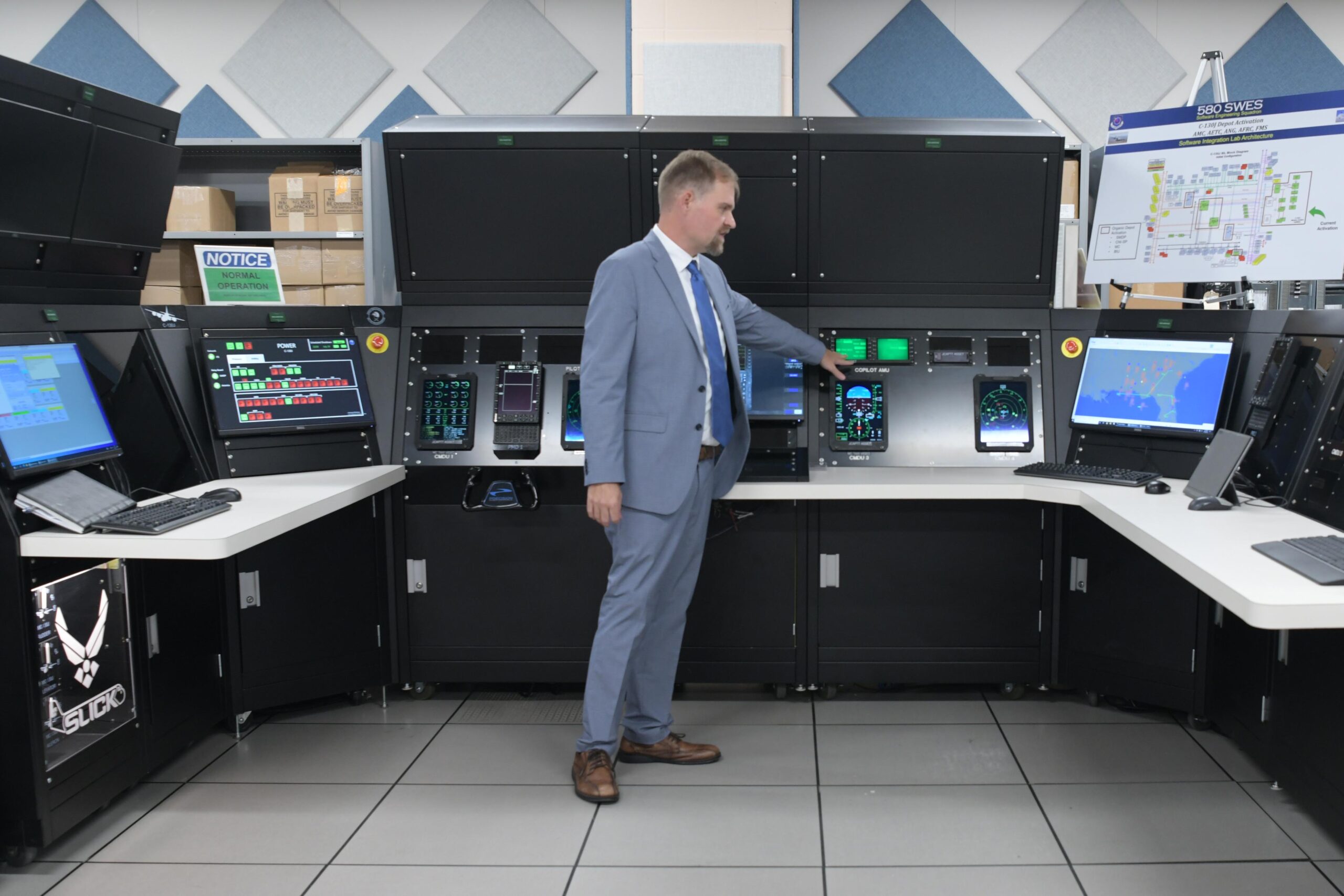 ROBINS AIR FORCE BASE, Ga. – Jacob Lunce, 580th Software Engineering Squadron technical specialist, discusses the new Special Mission Display Processor at Robins Air Force Base, Georgia, July 30, 2024, that will function on the C-130J aircraft. The deployed SMPD launched in July 2024 and will enhance avionics capabilities and improve mission situational awareness. (U.S. Air Force photo by Kisha Foster Johnson)