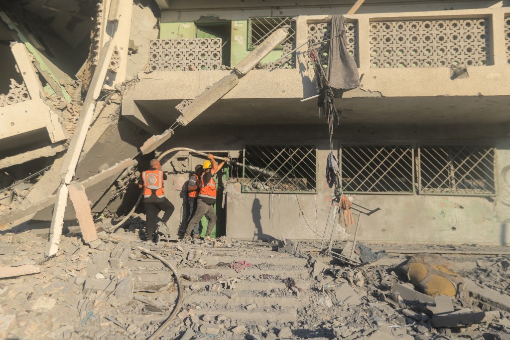 Palestinian rescue team members extinguish a fire in a destroyed building following Israeli bombardment, which hit a school complex in the north of Gaza City on August 3, 2024