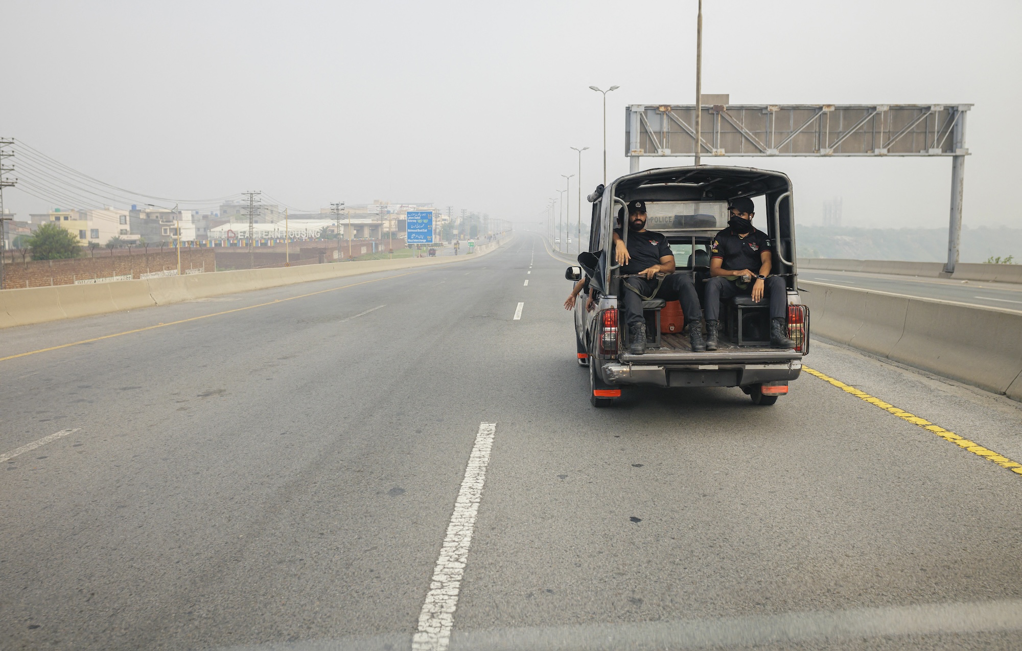 Pakistani police officers in a car on a highway in Lahore