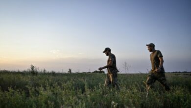 Servicemen of the 24th King Danylo Separate Mechanized Brigade are walking through a field during a combat mission near Chasiv Yar