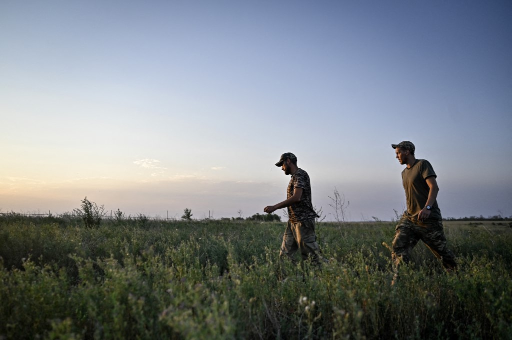 Servicemen of the 24th King Danylo Separate Mechanized Brigade are walking through a field during a combat mission near Chasiv Yar