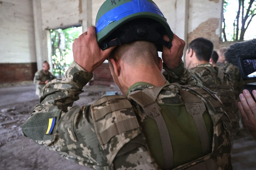 A Shkval (Squall) Battalion serviceman is holding a helmet during drills in Ukraine