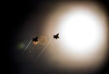 A pair of F-35 Lightning IIs pass under the sun while doing maneuvers to the Eglin Air Force Base runway