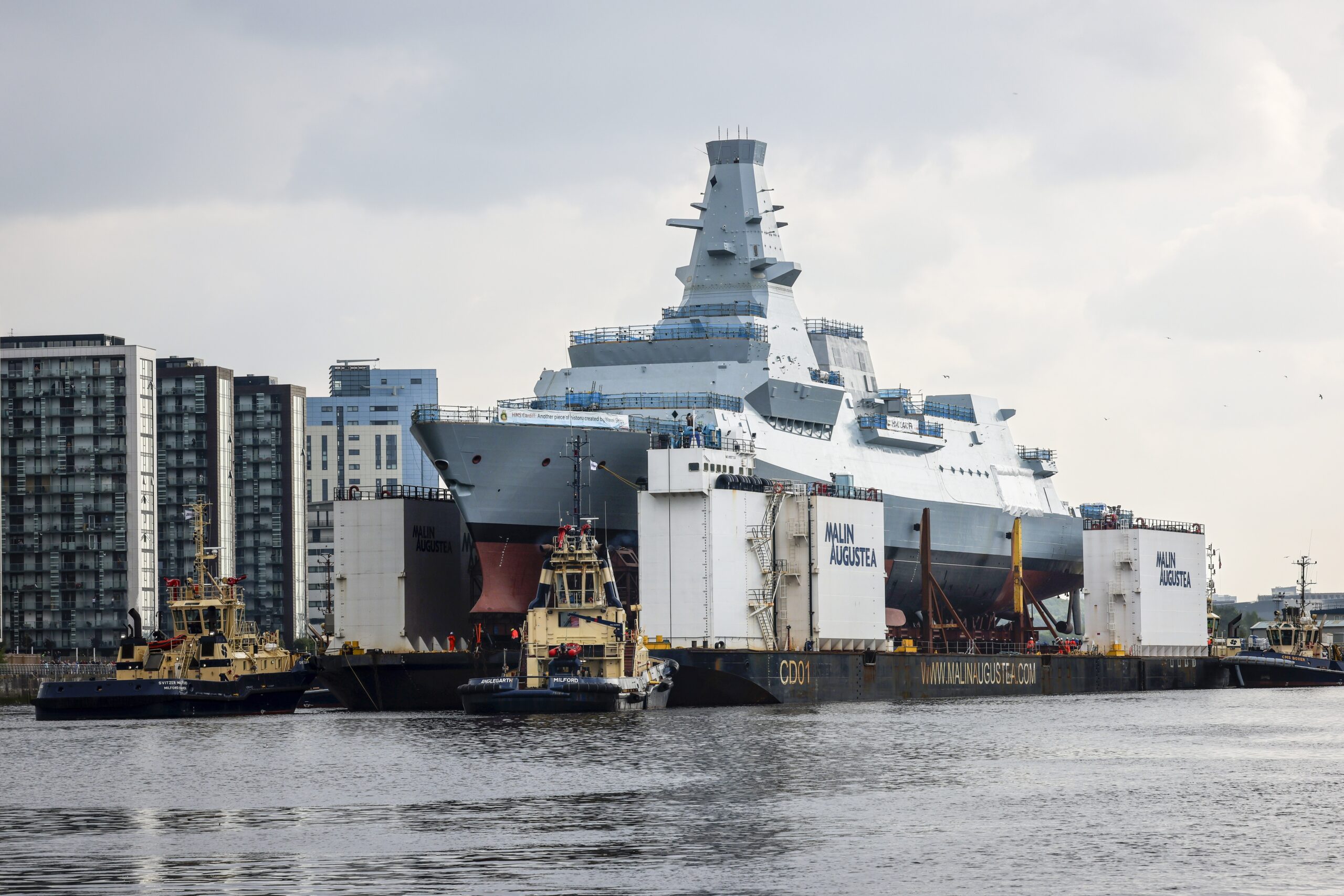 Pictured: Type 26 Frigate HMS Cardiff being moved to Loch Long. HMS Cardiff, the second of the Royal Navys new City Class Type 26 frigates, was loaded onto a giant barge last week. The ship, which weighs almost 7,000 tonnes, sailed down the River Clyde on Friday, August 30 to Loch Long, where she will be lowered into the water for the first time at Glen Mallan. Once HMS Cardiff is in the water, she will make her way back up the Clyde to BAE Systems yard at Scotstoun where the work to fit the warship out will be completed. Currently Scottish shipyards have orders to build 13 Royal Navy frigates, with the Type 31 vessels being built by Babcock at Rosyth on the east coast, and the Type 26 ships being constructed by BAE Systems on the Clyde.