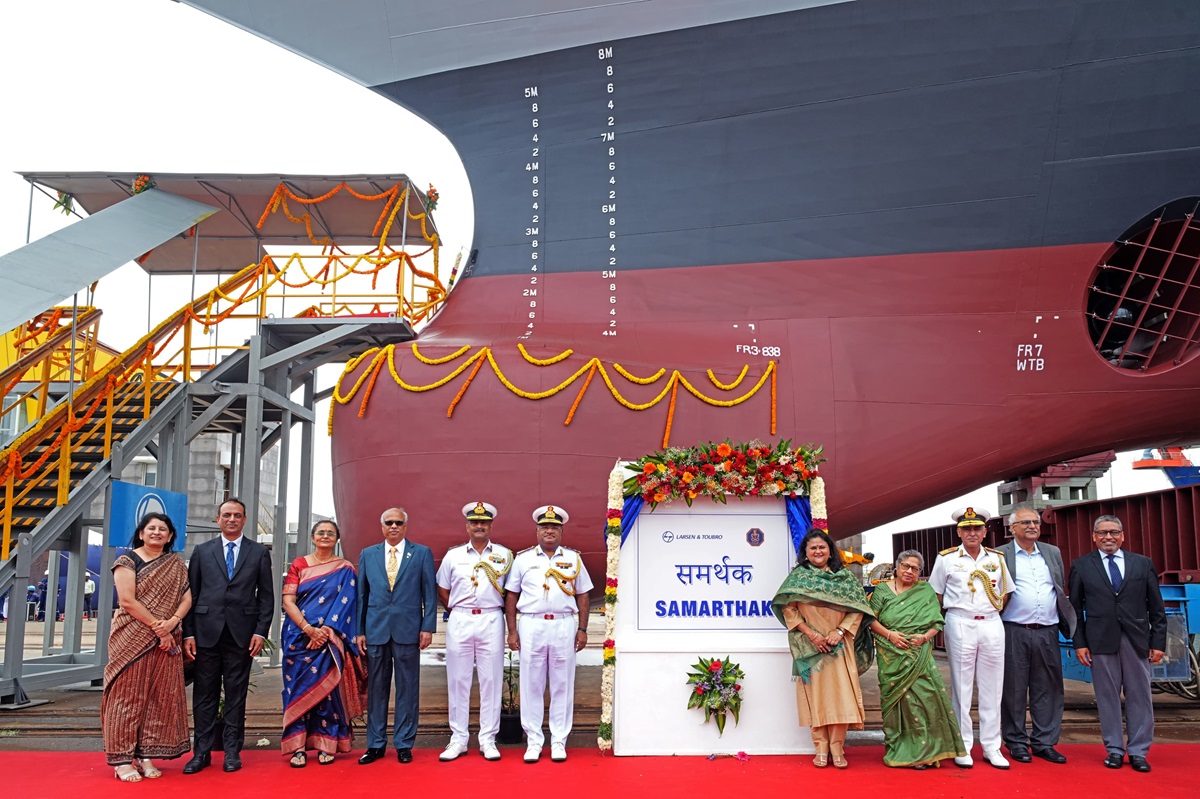 Indian Navy officials pose in front of the Samarthak multipurpose vessel