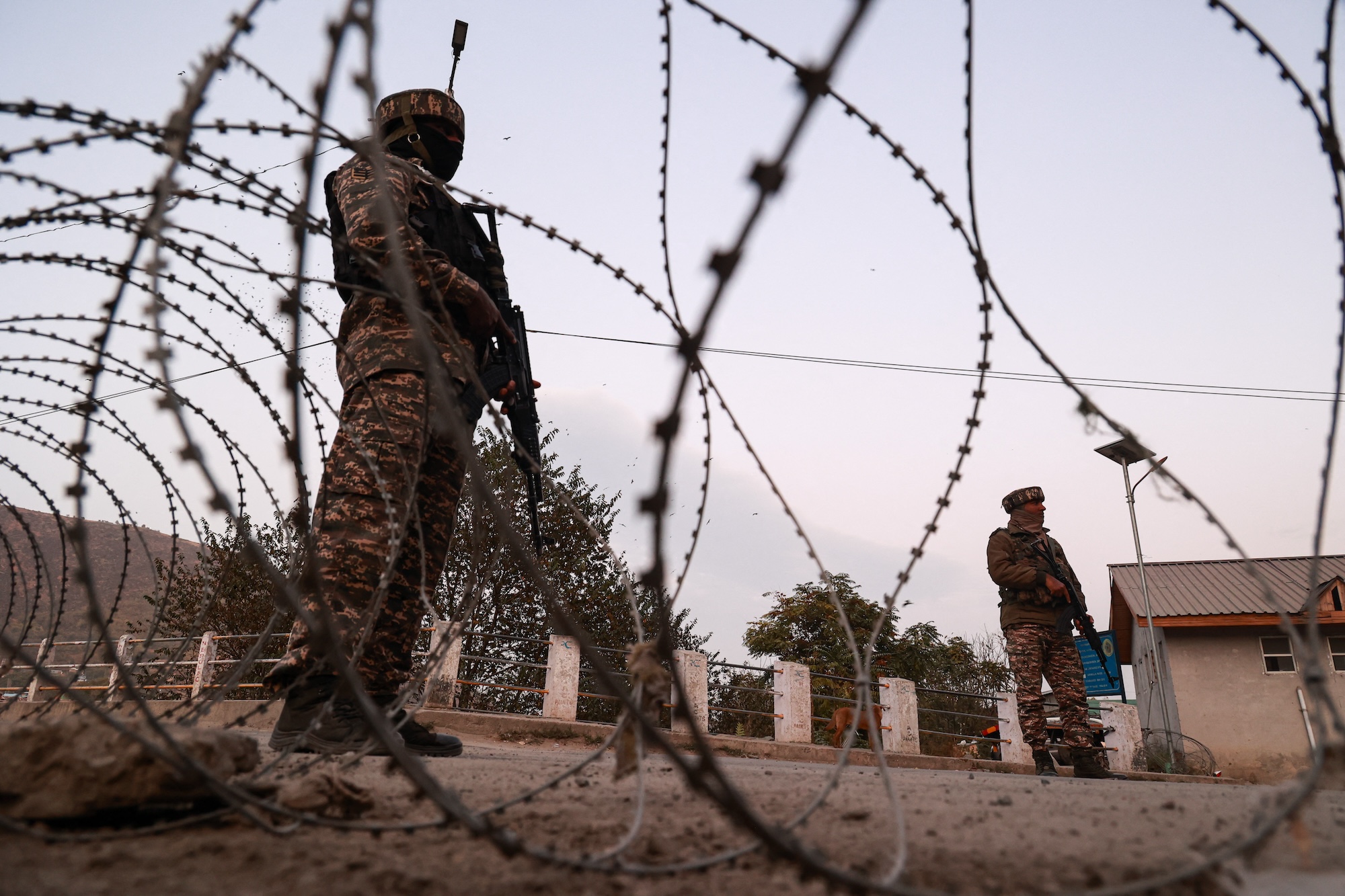 Indian soldiers stand alert while frisking vehicles and suspected persons in Baramulla, Jammu and Kashmir, India