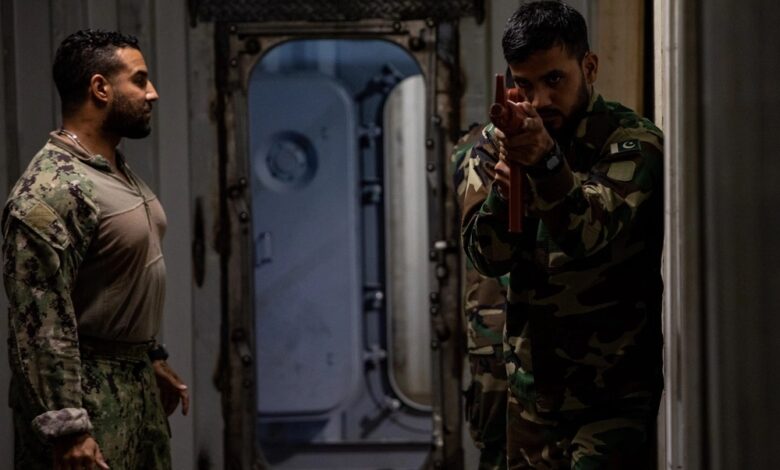 A US Coast Guard Maritime Law Enforcement Specialist oversees Pakistan Navy members during a visit, board, search and seizure training