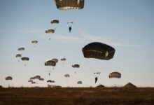 Paratroopers float to earth as part of the re-invigorated Saturday Proficiency Jump Program, Nov. 21, 2015, on Sicily Drop Zone. The once popular program was restarted in October to allow paratroopers to build additional proficiency and confidence for airborne operations. In November the program continued to build momentum with an additional 150 jumpers. Families and friends gathered on Sicily Drop Zone to watch the daytime spectacle and share in the unique U.S. Army paratrooper experience. (U.S. Army photo by Staff Sgt. Charles Crail, XVIII Airborne Corps/Released)