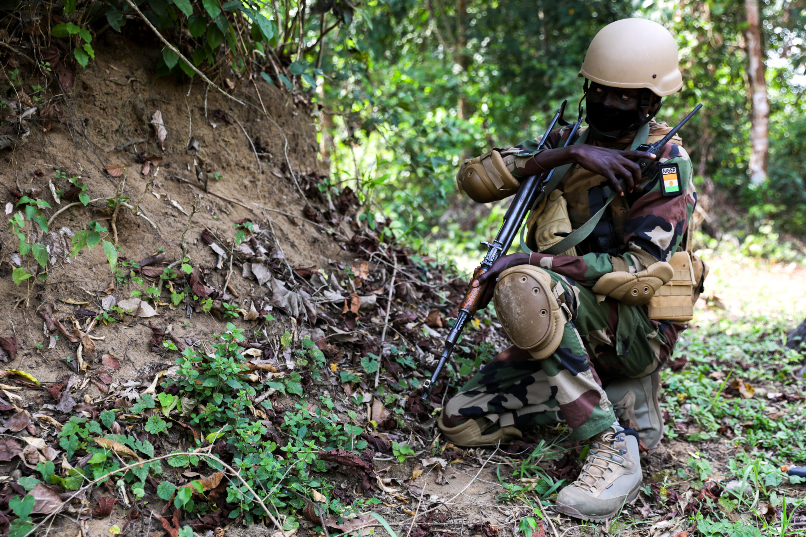 A Nigerien Special Forces Soldier communicates on a radio while conducting a raid during Flintlock 2022, in Côte d'Ivoire, Feb. 26, 2022. Flintlock is a multi-national exercise consisting of 11 nations training in Côte d'Ivoire. Flintlock helps strengthen the ability of allies and partners to counter violent extremism and provide security for their people. (U.S. Army photo by Sgt. Kacie Benak)