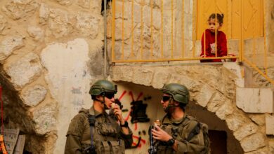 A child watches as Israeli soldiers secure the area during a tour of Hebronís old city in the West Bank