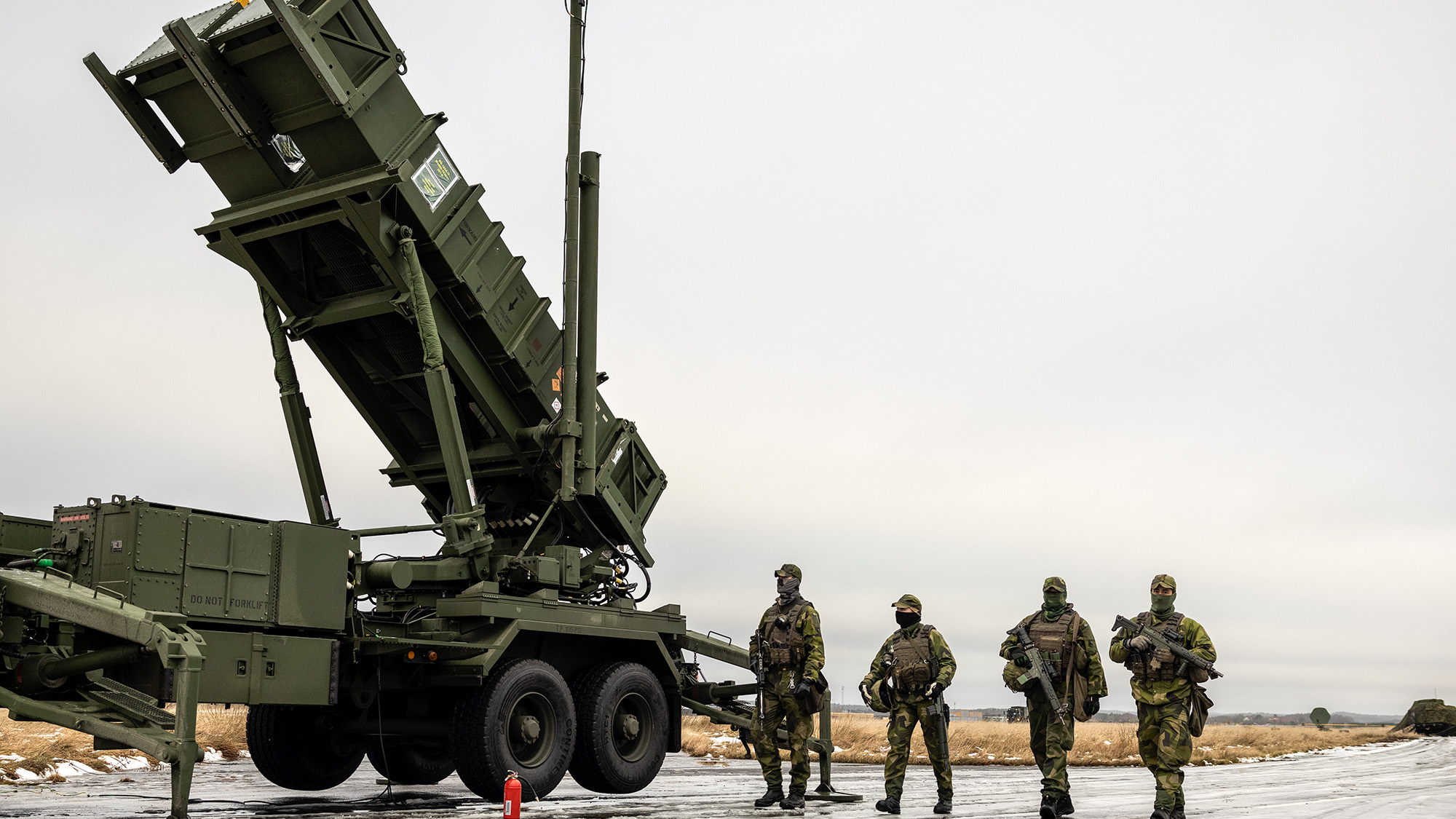 Swedish soldiers alongside a Patriot air defense system.