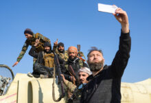 Anti-government fighters pose for a "selfie" picture on a Syrian regime military aircraft at the Kweyris military airfield in the eastern part of Aleppo province on December 3, 2024. (Rami al Sayed/AFP)