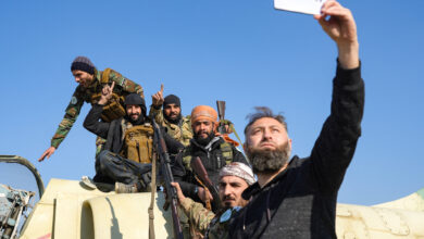 Anti-government fighters pose for a "selfie" picture on a Syrian regime military aircraft at the Kweyris military airfield in the eastern part of Aleppo province on December 3, 2024. (Rami al Sayed/AFP)