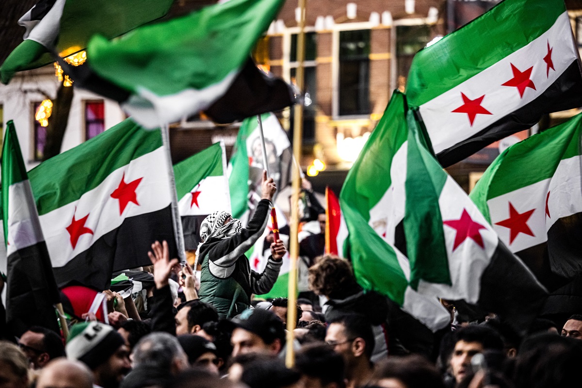 UTRECHT - The fall of the Assad regime in Syria is celebrated during a demonstration near Domplein. As in other countries, people are taking to the streets in joy over the departure of Syrian leader Bashar al Assad. ANP ROB ENGELAAR netherlands out - belgium out (Photo by ROB ENGELAAR / ANP MAG / ANP via AFP)