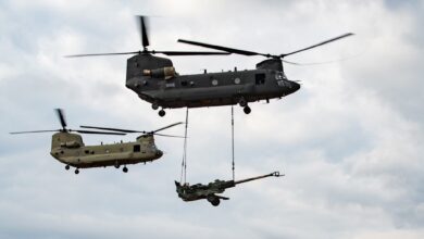 A US Army CH-47F Block II Chinook conducts a sling load test alongside a CH-47F Block I aircraft