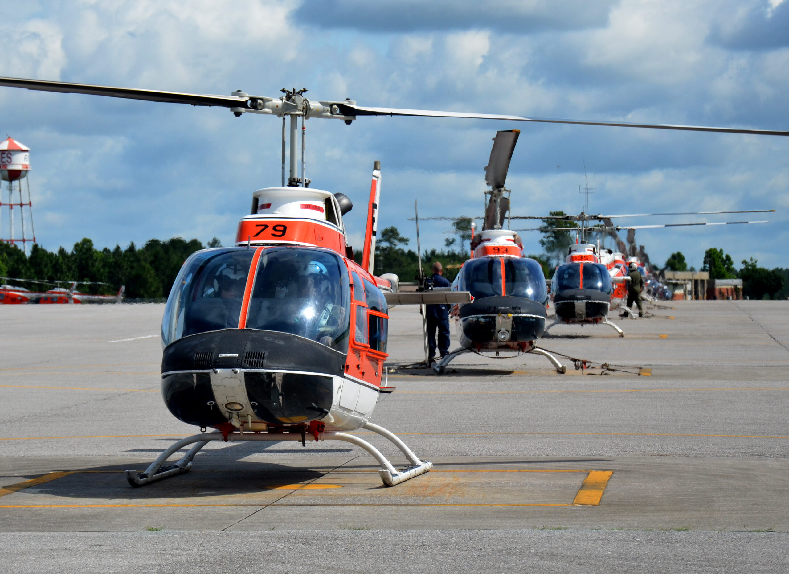 A row of TH-57 Sea Ranger helicopters waits on the runway at Naval Air Station Whiting Field, June 9, 2014. During the advanced flight training phase of a two-year-long flight school course, future Coast Guard pilots train for 7-8 months in the TH-57, learning aircraft systems and avionics, routine and emergency procedures, flight planning, risk management techniques, and earning their instrument rating, which allows them to fly in clouds and restricted visibility.