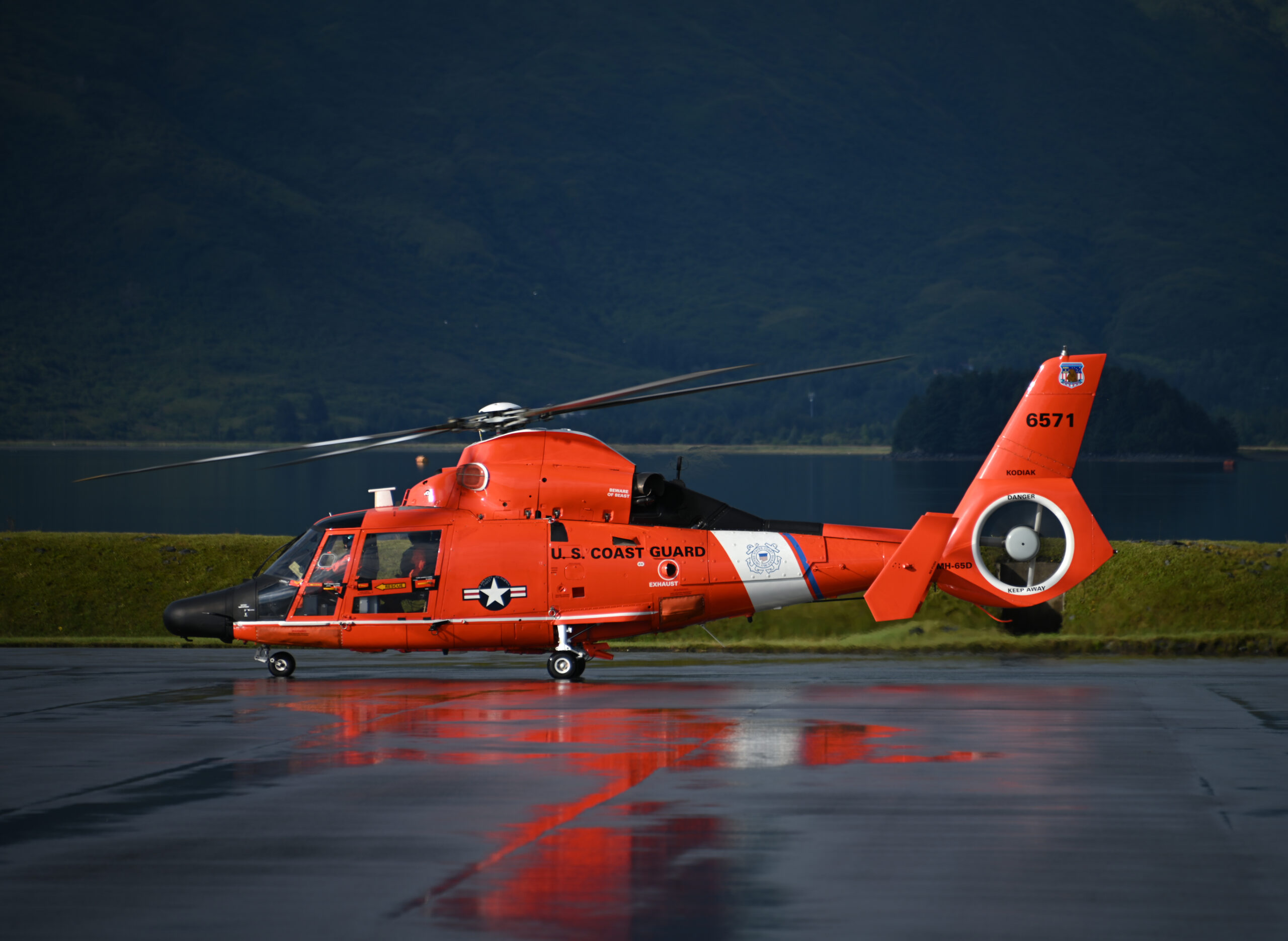 A Coast Guard Air Station Kodiak MH-65 Dolphin helicopter taxis to the tarmac at Coast Guard Base Kodiak, Alaska, on Aug. 17, 2022. This aircraft is a short-range recovery helicopter that completes search and rescue, law enforcement and aids to navigation missions. U.S. Coast Guard photo by Petty Officer 3rd Class Ian Gray.