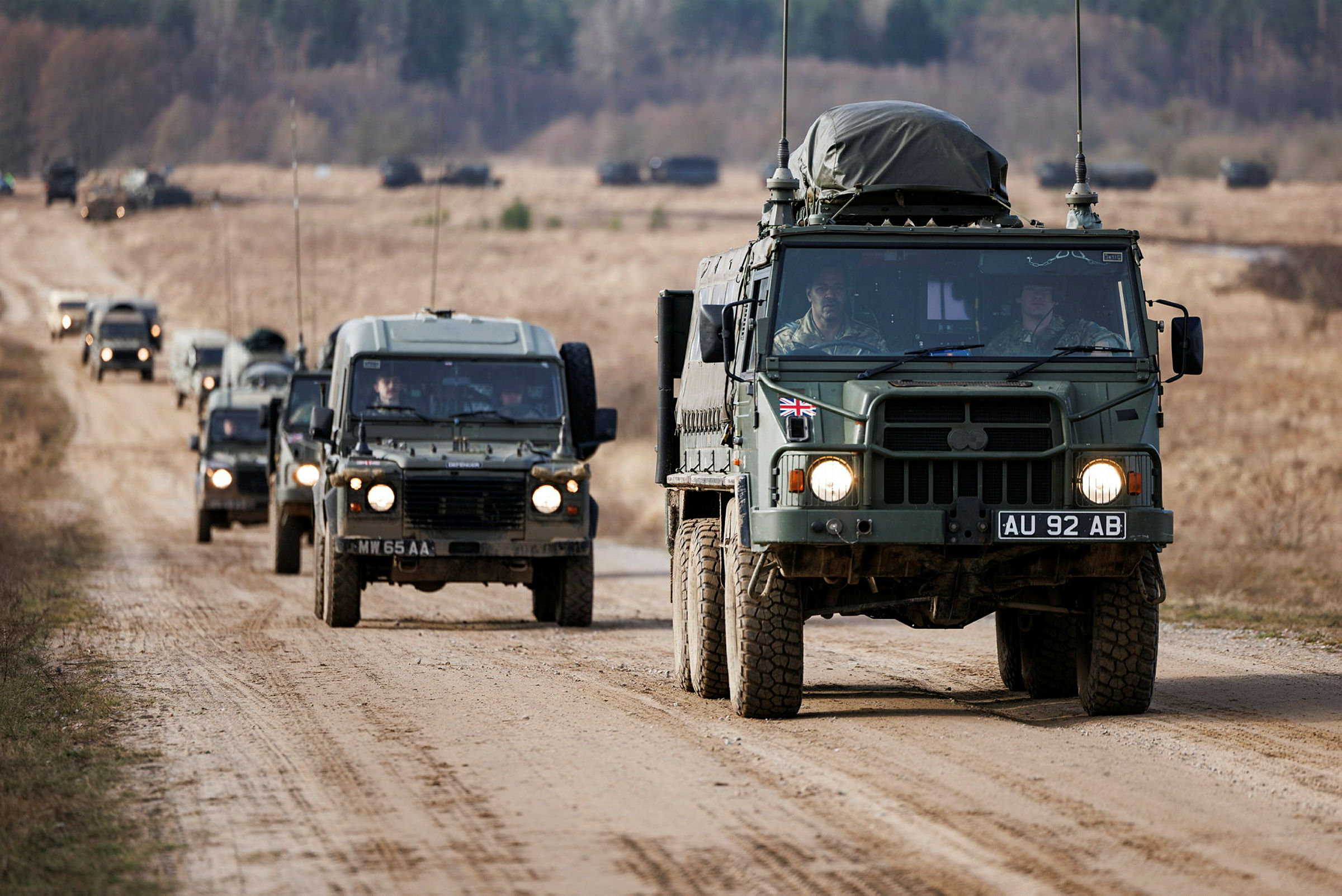 A line of Land Rover Wolf 4x4 Utility vehicles follow a Pinzgauer 6x6 All Terrain Truck on the Drawsko Pomorskie Training Area (DPTA) for Exercise Steadfast Defender 2024. Approximately 400-500 military vehicles and 1500 military personnel taking part in Ex STEADFAST DEFENDER line up on DPTA, Poland, for a Battle Group photo. 16,000 British soldiers are taking part in the largest set of NATO multi-national military manoeuvres in generation. Exercise Steadfast Defender will see these troops deploy across the entirety of Europe’s eastern flank, stretching from the far north of Norway, inside the Arctic Circle, all the way down to Georgia in the Caucasus’s. The British Army will be at the very forefront over the 5-month duration of Exercise Steadfast Defender, underpinning its position not only as the leading NATO European member state, but also one of its most potent. To put that into perspective; the Army is committing a 3* Headquarters, as well as two 2* Divisional and three 1* Combat Brigade Headquarters. These deployed formations will test, evaluate, and prove our ability to integrate and operate alongside our partners and allies, strengthening that collective and sustained commitment to European security. Along with those 16,000 troops, the UK will be sending massed armour including main battle tanks across to Europe aboard Ro-Ro vessels and loaded onto trains through the Channel Tunnel. Paratroopers will fly in from UK bases to seize strategic objectives and link up with NATO allied forces. Exercise Steadfast Defender will run from January through to May and comprise of 11 individual exercises in which British forces will participate alongside our NATO allies and partners.