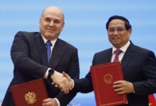 Russian Prime Minister Mikhail Mishustin shakes hands with Vietnamese Prime Minister Pham Minh Tinh