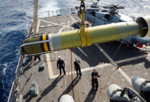 Sailors aboard the Arleigh Burke-class guided-missile destroyer USS Winston S. Churchill (DDG 81) maneuver a Mark-54 torpedo to the flight deck.