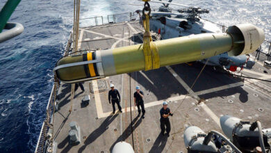 Sailors aboard the Arleigh Burke-class guided-missile destroyer USS Winston S. Churchill (DDG 81) maneuver a Mark-54 torpedo to the flight deck.