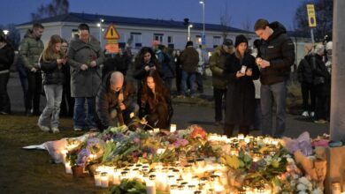 Mourners gather to place flowers and candles outside Risbergska School in Örebro the day after the school shooting in which 11 people lost their lives.