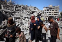 Palestine residents crying and walking over a rubble of a building after an Israeli strike