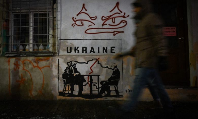 A mural titled 'Divided by Oligarchy' by anonymous Norwegian street artist Toddel, depicting US President Donald Trump and Russian President Vladimir Putin seated at a table next to a map of a divided Ukraine, is seen on a wall in Krakow, Poland, on January 29, 2026.