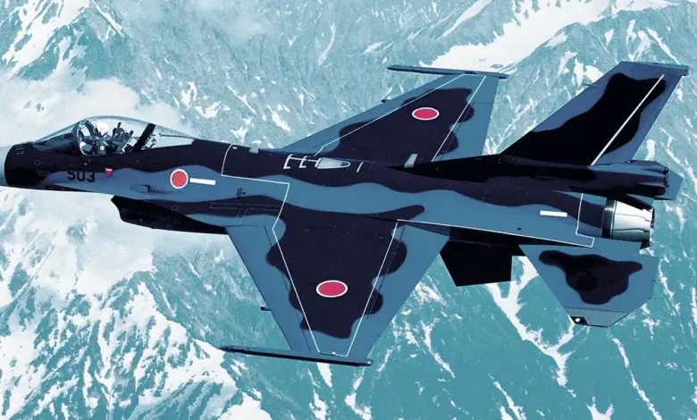 Japan Air Self-Defense Force F-2 fighter aircraft flying over snow-covered mountains.