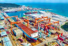 Aerial view of HD Hyundai Heavy Industries' Ulsan shipyard with ships under construction and multiple dry docks in South Korea.