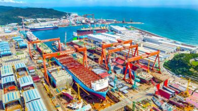 Aerial view of HD Hyundai Heavy Industries' Ulsan shipyard with ships under construction and multiple dry docks in South Korea.