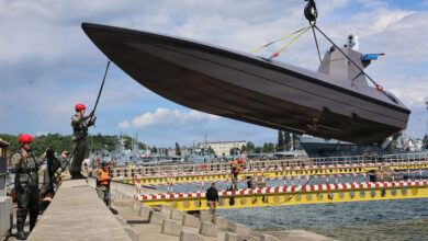 260612-N-LY640-1097 GDYNIA, Poland (June 12, 2026) – Lt. Jay Faylo, unmanned systems director of Commander Task Force 66 (CTF-66), directs the crane operator lowering a K3 Scout, an unmanned surface vessel, into the Port of Gdynia for acceptance and validation of the craft and capabilities development for project Vesuvius during exercise Baltic Operations (BALTOPS) 2026, June 12, 2026. BALTOPS 2026, the premiere maritime-focused exercise in the Baltic Sea region, provides a unique training opportunity to strengthen combined response capabilities critical to preserving freedom of navigation and security in the Baltic Sea. (U.S. Navy photo by Chief Mass Communication Specialist Sandi Grimnes Moreno)