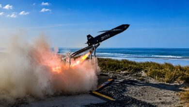 The MGI Defence TigerShark high-speed one-way effector launching from a coastal rail system with rocket booster ignition during test firings.