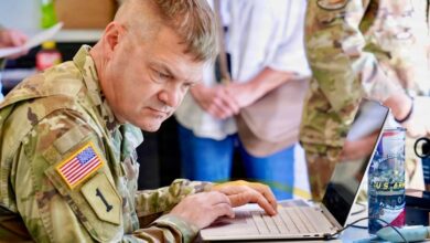 A US Army soldier works at a laptop