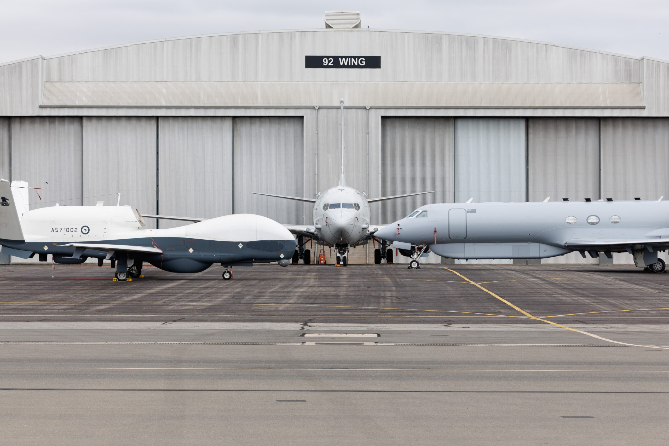 A Royal Australian Air Force P-8A Poseidon aircraft representing No. 11, No. 12, and No. 292 Squadrons (centre), an MQ-4C Triton from No. 9 Squadron (left), and an MC-55A Peregrine from No. 10 Squadron representing the Air "ISR Family" of jets in No. 92 Wing at RAAF Base Edinburgh, South Australia. This image has been digitally altered. *** Local Caption *** On Tuesday 22 September 2026, Acting Prime Minister and Minister for Defence, the Honourable Richard Marles MP, accompanied by Chief of Air Force Air Marshal Stephen Chappell DSC, CSC, OAM, visited RAAF Base Edinburgh to announce a series of significant milestones for Australia's Air Intelligence, Surveillance and Reconnaissance (Air ISR) capabilities. The Acting Prime Minister announced the achievement of Initial Operational Capability (IOC) for the MQ-4C Triton and MC-55A Peregrine, the completion of major upgrades to the first two P-8A Poseidon aircraft in Australia's fleet in the United States, and the forthcoming commencement of upgrades to the remaining fleet at the recently opened Deep Maintenance and Modification Facility at RAAF Base Edinburgh. These milestones represent a significant enhancement to the Royal Australian Air Force's ability to deliver persistent intelligence, surveillance and reconnaissance effects across Australia's primary area of military interest. RAAF Base Edinburgh is the Royal Australian Air Force's principal Air ISR hub and home to No. 92 Wing, which operates the P-8A Poseidon, MQ-4C Triton and MC-55A Peregrine through Nos. 9, 10, 11, 12 and 292 Squadrons. Built through years of collaboration between Defence, industry and the United States, Australias integrated Air ISR fleet continues to grow.